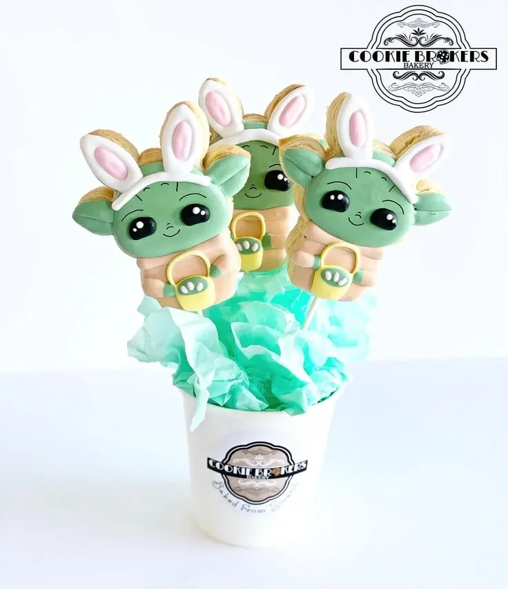 These Baby Yoda Easter Cookie Pops feature Baby Yoda wearing bunny ears and holding an Easter Basket.